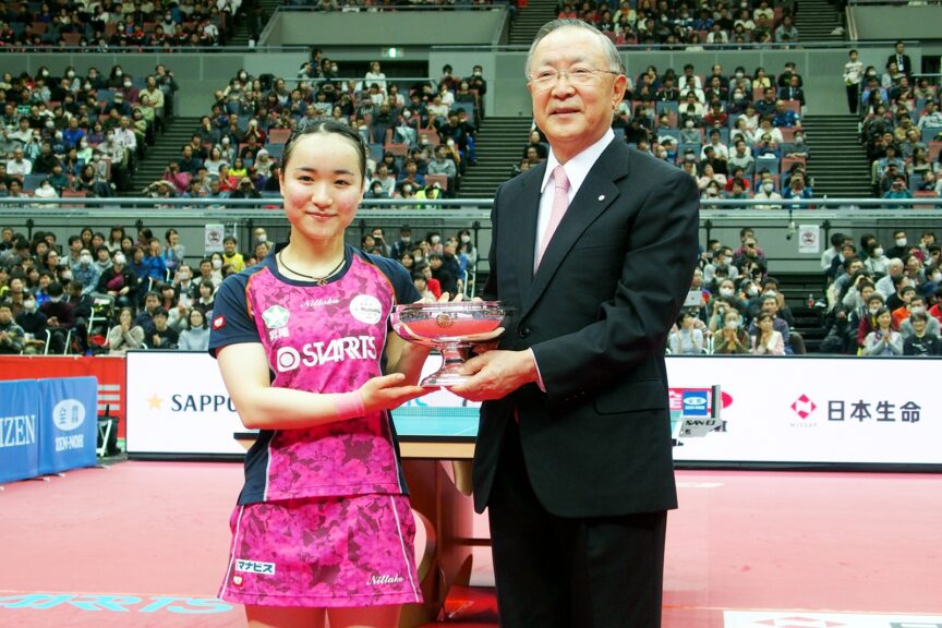 優勝してカップを受け取る伊藤美誠と日本卓球協会会長の藤重貞慶【JTTA】